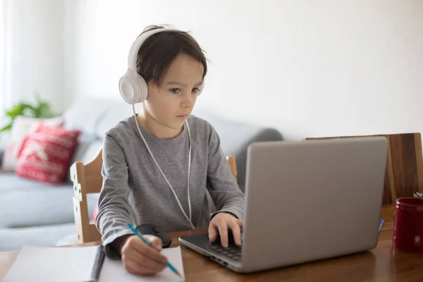 Criança Escolar Sentada Mesa Com Laptop Escrevendo Tarefas Escolares Enquanto — Fotografia de Stock