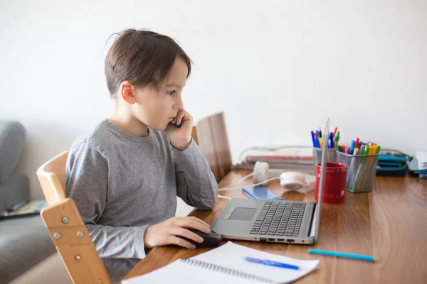 Criança Escolar Sentada Mesa Com Laptop Escrevendo Tarefas Escolares Enquanto — Fotografia de Stock