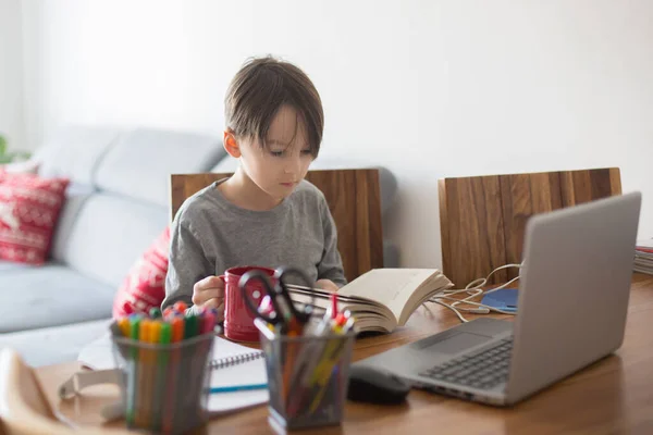 Criança Escolar Sentada Mesa Com Laptop Escrevendo Tarefas Escolares Enquanto — Fotografia de Stock
