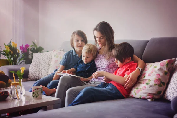 Mujer Joven Madre Con Tres Hijos Leyendo Libro Casa Abrazando —  Fotos de Stock