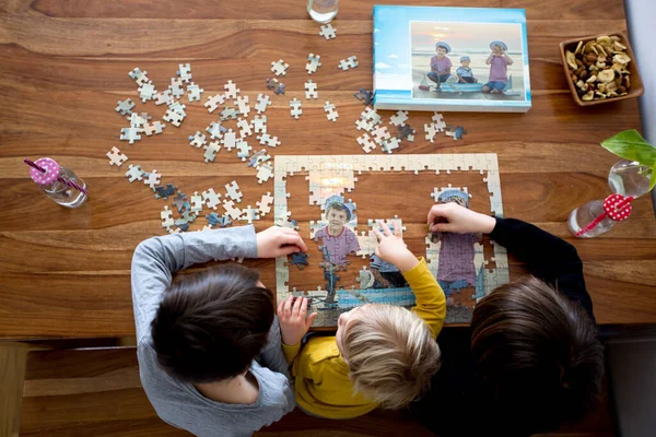 3人の子供 男の子 ビーチからの写真でパズルを組み立て 一緒に家で遊ぶ — ストック写真