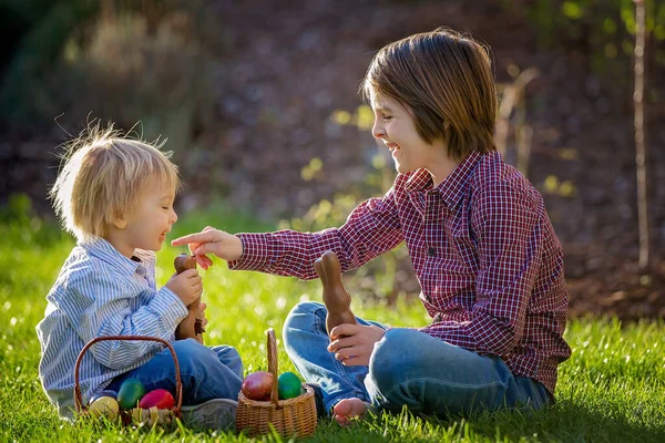 可爱的孩子们 在日落时在花园里打猎 吃巧克力兔 吃着复活节彩蛋 — 图库照片
