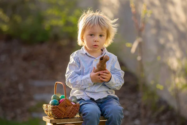 Küçük Çocuk Gün Batımında Bahçede Çikolatalı Tavşan Yiyor Etrafında Paskalya — Stok fotoğraf