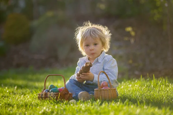 Piccolo Bambino Mangiare Coniglietto Cioccolato Giardino Tramonto Uova Pasqua Intorno — Foto Stock