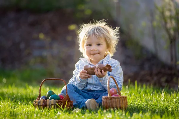 Piccolo Bambino Mangiare Coniglietto Cioccolato Giardino Tramonto Uova Pasqua Intorno — Foto Stock