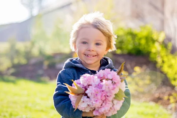 Lieve Blonde Jongen Met Roze Bloemen Tuin Bij Zonsondergang — Stockfoto