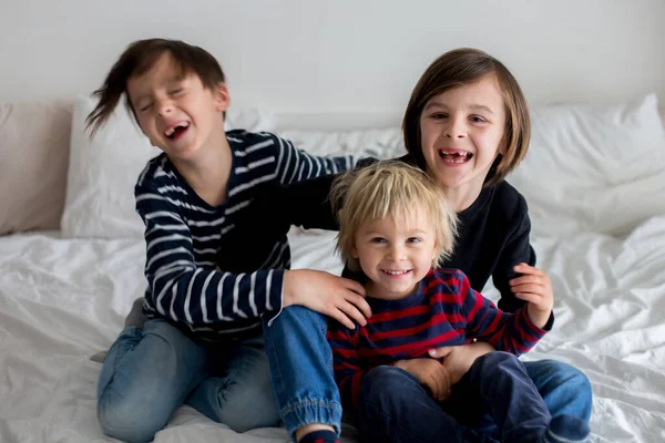 3人の子供 男の子の兄弟 ベッドで笑い そしてくすぐる — ストック写真