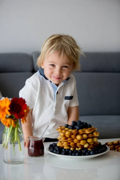 可爱的幼儿 在家里吃带有水果的泡泡华夫饼当早餐 桌上放花 — 图库照片