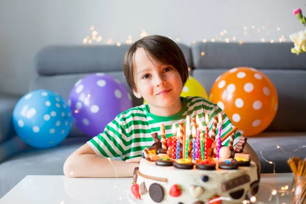 甘い子供 上にチョコレートの多くと自家製の誕生日ケーキで彼の誕生日を迎えます クッキーとイチゴ — ストック写真