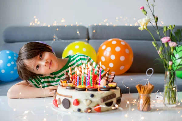 甘い子供 上にチョコレートの多くと自家製の誕生日ケーキで彼の誕生日を迎えます クッキーとイチゴ — ストック写真