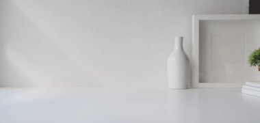 Kopya alanı olan en küçük çalışma alanı ve beyaz ahşap masa ve beyaz duvar arkaplanı üzerine çerçeve 