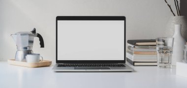 Kahve fincanı ve ofis malzemeleriyle boş dizüstü bilgisayarı olan modern çalışma alanı.