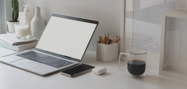 Espacio de trabajo mínimo con ordenador portátil de pantalla en blanco abierto y suministros de oficina en mesa de madera blanca —  Fotos de Stock