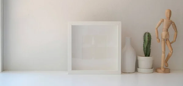 Modern workspace with mock up frame and office decorations on white table and white wall background