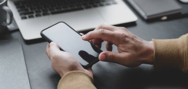 Profesyonel iş adamının karanlık lüks ofis odasında akıllı telefona dokunduğu görüntüler.  