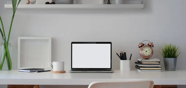 Comodo spazio di lavoro con computer portatile a schermo vuoto aperto e modello di cornice con forniture e decorazioni per ufficio — Foto Stock