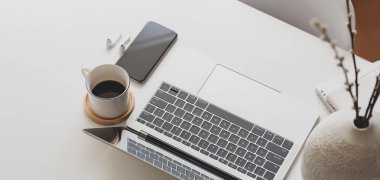 Laptop bilgisayarı ve ofis malzemeleri beyaz ahşap masa üzerinde modern çalışma alanının yakın görüntüsü 