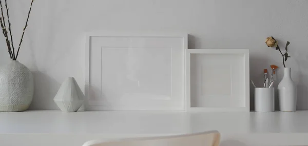 Salle de bureau minimale avec des cadres maquillés et des décorations de vase en céramique blanche sur la table blanche — Photo