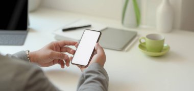 Profesyonel iş adamının rahat ofisinde boş ekran akıllı telefonu tutarken yakın plan görüntüsü. 