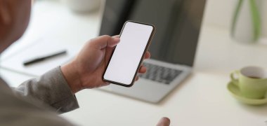 Profesyonel iş adamının rahat ofisinde boş ekran akıllı telefonu tutarken yakın plan görüntüsü. 
