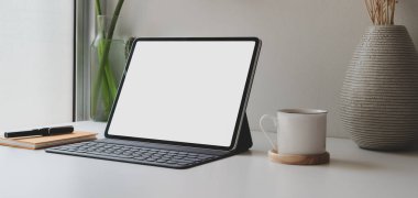 Boş ekran dijital tablet ve rahat iş yerinde kahve fincanı ile ofis malzemeleri. 