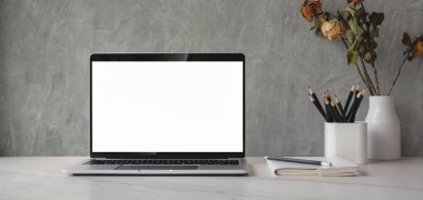 Ofis malzemeleri ve kuru gül vazosu süslemeleri ile boş ekran bilgisayar ile kırpılmış çekim 