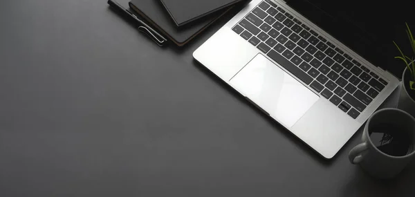 Overhead shot of dark stylish workspace with laptop computer black notebook on black table background — Stock Photo, Image