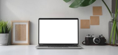 Boş dizüstü bilgisayarı olan modern ofis odası ofis malzemeleri ve duvarında yapışkan bir not olan kamera. 