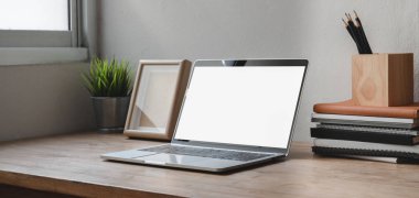 Boş bilgisayar ve ofis malzemeleriyle rahat çalışma alanının kırpılmış görüntüsü.