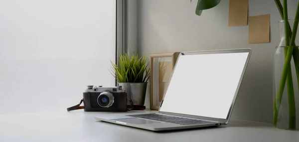 Moderna sala de oficina con computadora portátil de pantalla en blanco y cámara con suministros de oficina y nota adhesiva en la pared —  Fotos de Stock