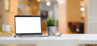 Laptop bilgisayarı ve ofis arka planına sahip ağaç kaplamalı rahat iş yeri görüntüsü 