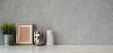 Ofis malzemeleri ve beyaz masa ve tavan arası gri duvar arkaplanı üzerine kopyalama alanı olan moda bir işyeri