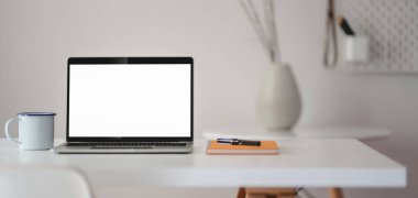 Ofis malzemeleri ve vazo süslemeleri ile birlikte dizüstü bilgisayarı açık modern iş yeri görüntüsü 