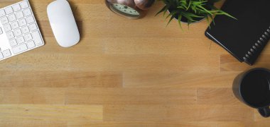 Klavye bilgisayarı ve ofis malzemeleriyle ahşap masada rahat bir iş yeri manzarası. 