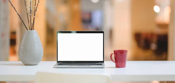 Laptop bilgisayarı, kırmızı kahve fincanı ve ofis arkaplanlı dekorasyonlu rahat iş yeri görüntüsü 