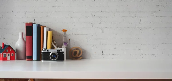 Plan recadré d'un lieu de travail vintage avec caméra et fournitures de bureau sur table en marbre et fond mural en brique — Photo