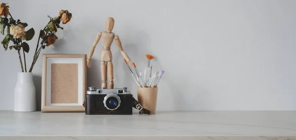 Minimális művészi munkahely irodai kellékekkel és fényképezőgéppel márványasztalon és másolótérben — Stock Fotó