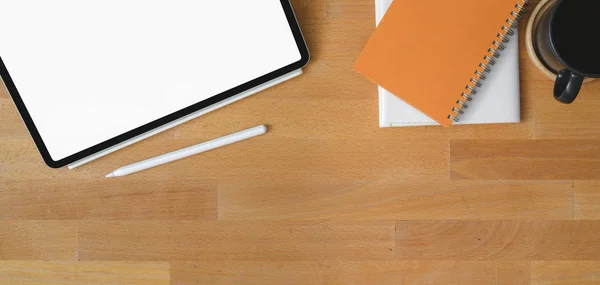 Vista superior del cómodo lugar de trabajo con tableta digital de pantalla en blanco y suministros de oficina en mesa de madera — Foto de Stock