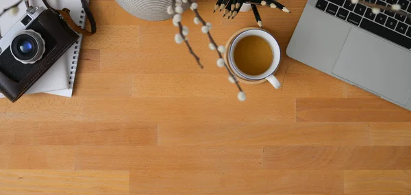 Top view of comfortable workplace with laptop computer, camera and office supplies on wooden table with copy space — Stock Photo, Image