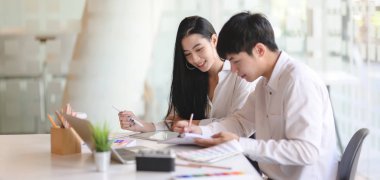 Bir grup genç profesyonel tasarımcı rahat ofis odasında projelerinde birlikte çalışıyorlar.  