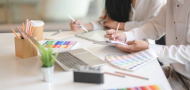 Grafik tasarımcılarının modern ofis odasında fikirlerini paylaşırken çekilmiş görüntüler. 