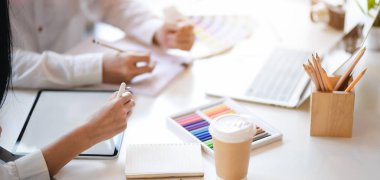 Genç profesyonel grafik tasarımcı ekibinin boş ekran dijital tabletle birlikte kavramları üzerinde çalışırken çekilmiş görüntüleri. 