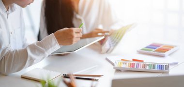 Modern ofis odasında fikirleri paylaşan tutkulu grafik tasarımcı takımının yakın görüntüsü 