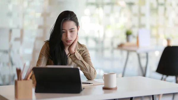 Schnappschuss einer jungen schönen Geschäftsfrau bei der Arbeit an ihrem Projekt mit Tablet im modernen Büroraum — Stockfoto