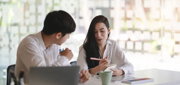 Dos jóvenes diseñadores gráficos profesionales que intercambian su idea juntos en la moderna sala de oficina — Foto de Stock