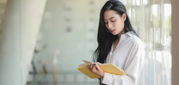 Retrato de jovem mulher de negócios bonita lendo o documento enquanto estava em seu quarto de escritório moderno — Fotografia de Stock