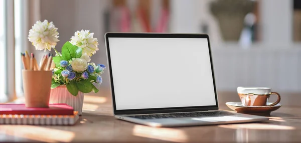 Vista ravvicinata di un posto di lavoro confortevole con computer portatile e forniture per ufficio su un tavolo di legno accanto alle finestre — Foto Stock