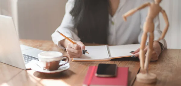 Vista de cerca de la empresaria que trabaja en su proyecto actual mientras escribe sus conceptos de idea en su cuaderno —  Fotos de Stock