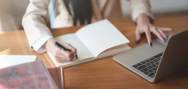 Vista de cerca de la joven empresaria que trabaja en su proyecto y escribe sus ideas en un cuaderno en una cómoda sala de oficina — Foto de Stock