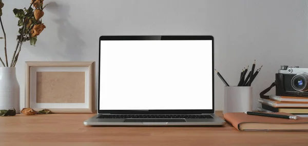 Удобное рабочее место с чистым экраном ноутбука с офисными принадлежностями на деревянном столе — стоковое фото